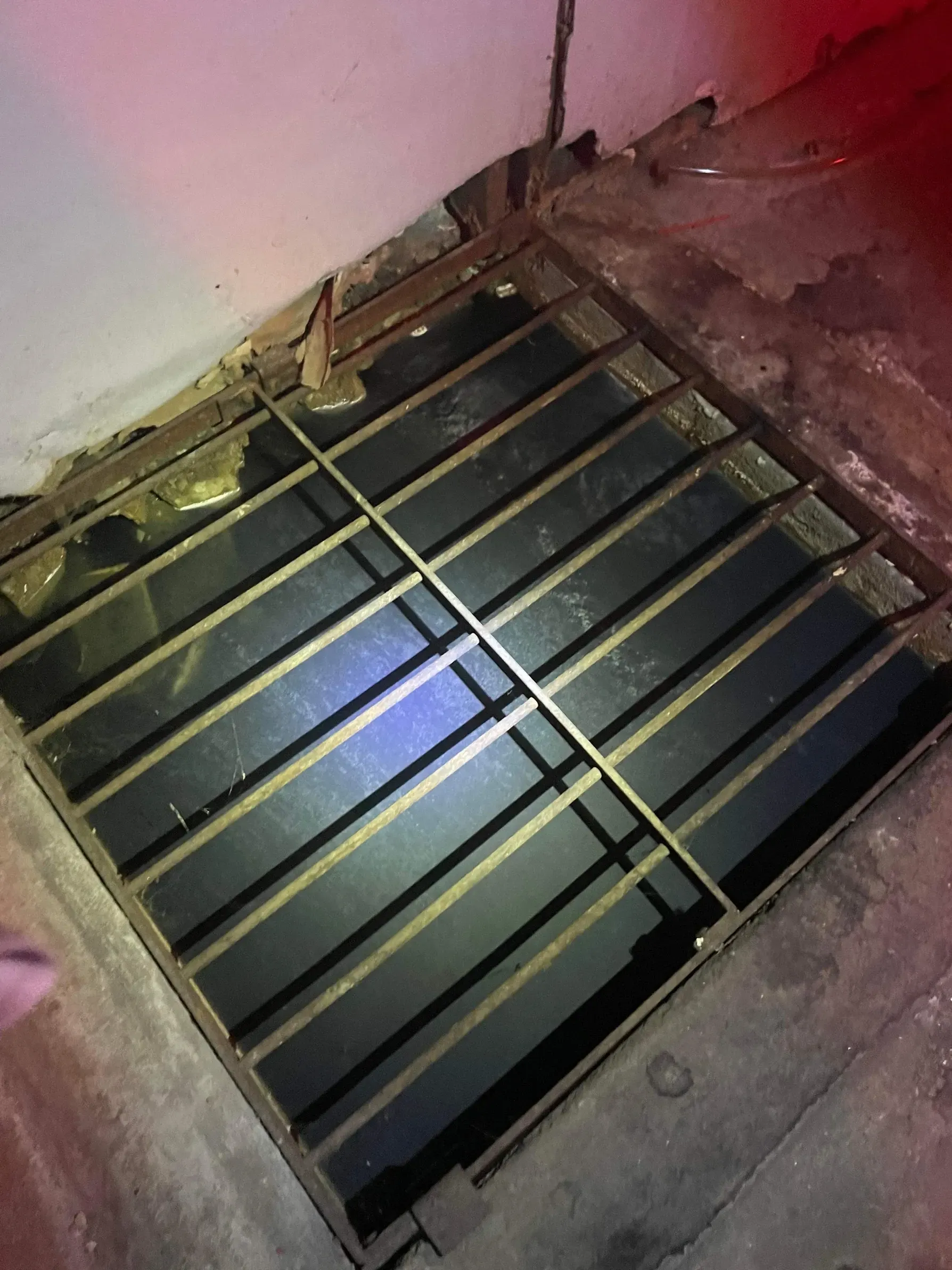 Square grate covering a pit