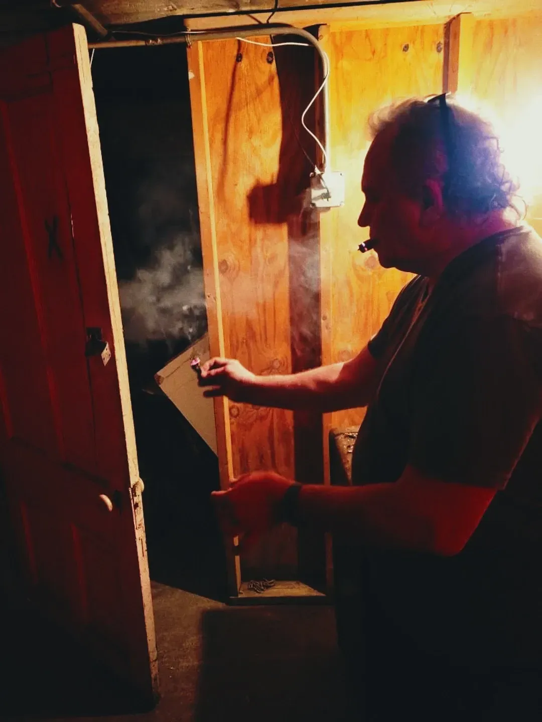 Man exhaling smoke in dark room