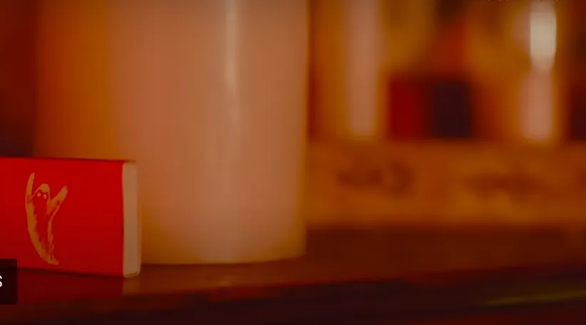 Red matchbox beside a candle
