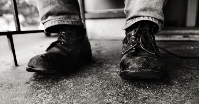 Worn leather boots on concrete floor