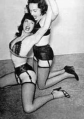 Women playfully wrestling in classic attire.