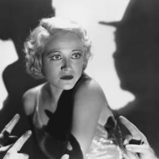 Woman surrounded by shadows, looking scared.