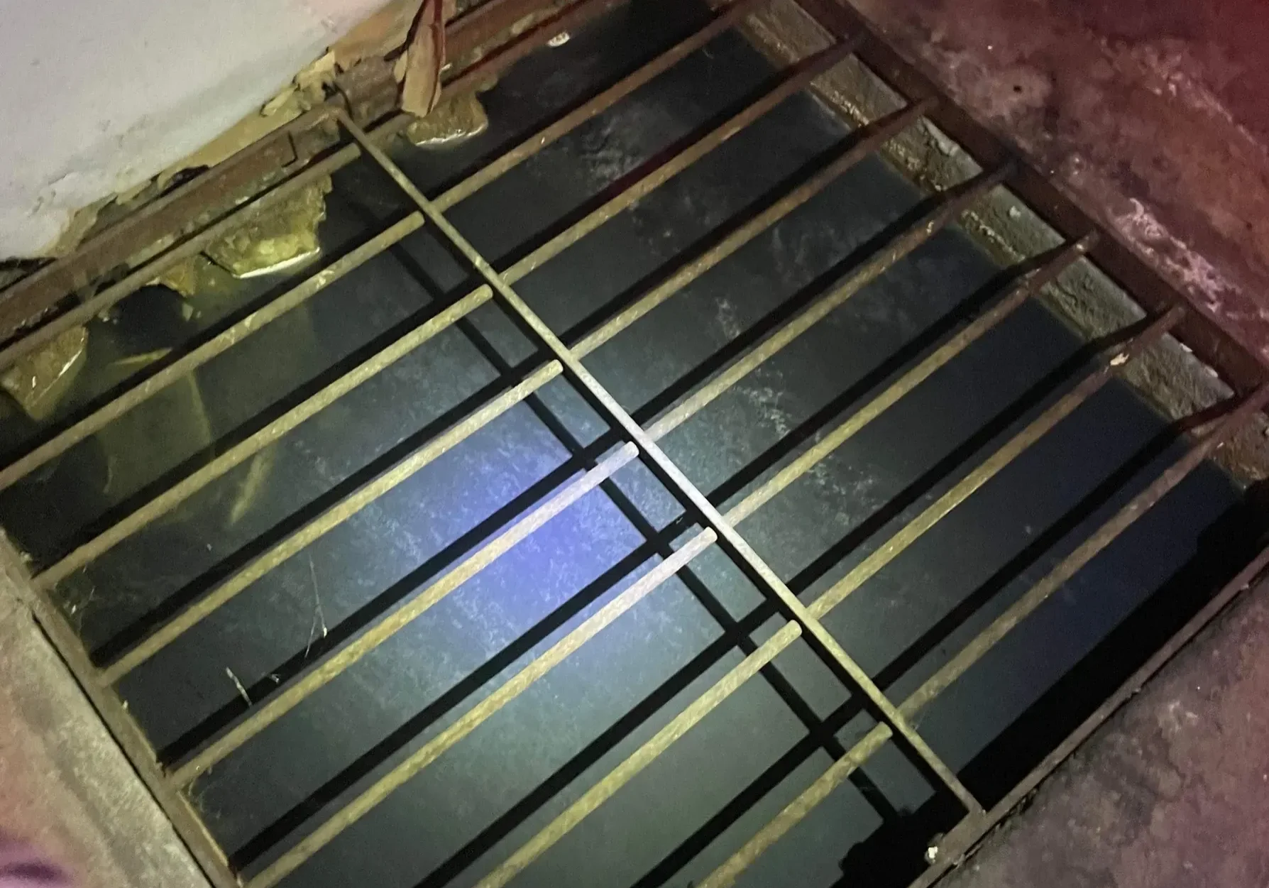 Square grate covering a pit