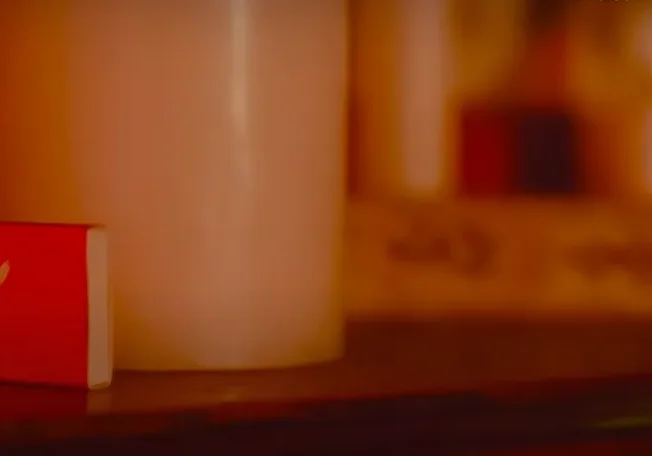 Red matchbox beside a candle