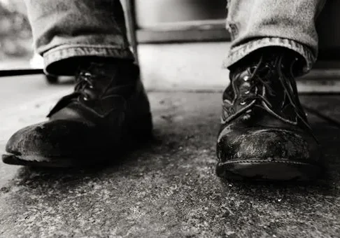 Worn leather boots on concrete floor